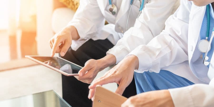 Profesionales de salud consultando información en una tablet